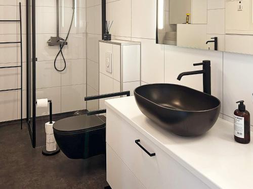 La salle de bains est pourvue d'un lavabo noir et de toilettes. dans l'établissement Holiday home HOVDEN II, à Hovden