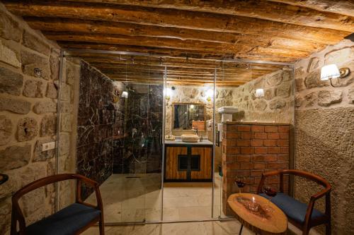 a bathroom with a shower and a table and chairs at Janus Cappadocia Hotel in Nevsehir