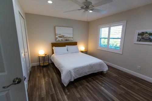 1 dormitorio con 1 cama y ventilador de techo en New Construction - Pristine Home - Great Location, en Stuart