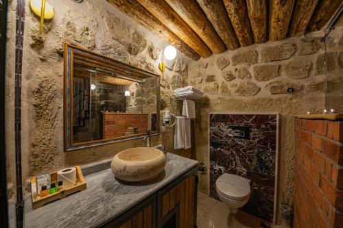 a stone bathroom with a sink and a toilet at Janus Cappadocia in Nevsehir