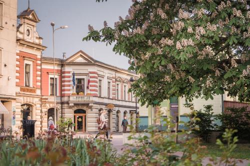 an old building with a statue in front of it at Art Hotel Roma in Liepāja