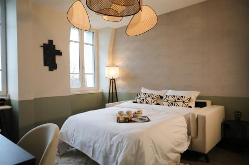 a bedroom with a bed with a tray of food on it at La Villa Ponsin in Cognac