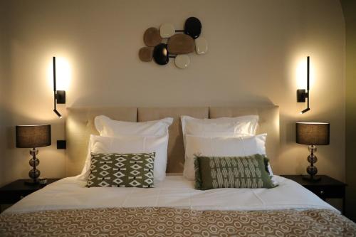 a bedroom with a white bed with two pillows at La Villa Ponsin in Cognac