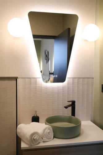a bathroom with a green sink and a mirror at La Villa Ponsin in Cognac