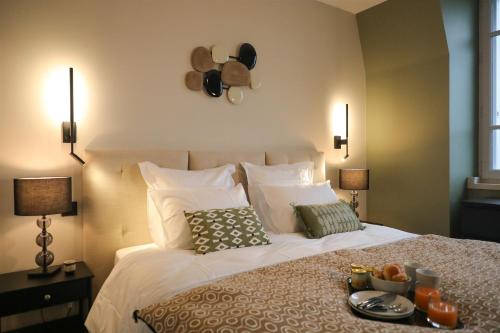 a bedroom with a bed with a tray of food on it at La Villa Ponsin in Cognac