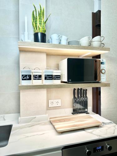 a kitchen with a counter with a microwave and appliances at Apartamentos Noja Playa in Noja