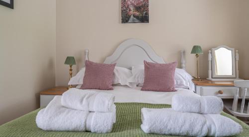 a bedroom with a white bed with two pillows at Can Brow in Rusland