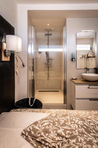 une salle de bain avec une douche, un lit et un lavabo dans l'établissement Cap d'Agde Suit'Appart 42m2 T2 Village Naturiste, au Cap d'Agde