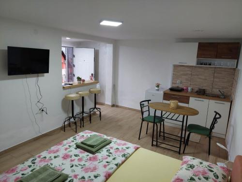 a living room with a table and a kitchen at Apartmani Kuljanin in Donji Milanovac