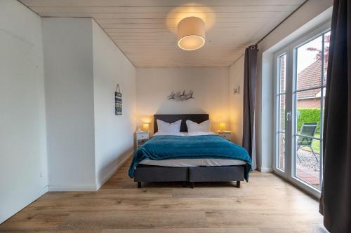 sypialnia z łóżkiem i dużym oknem w obiekcie Boutique 54° Nord w Büsum