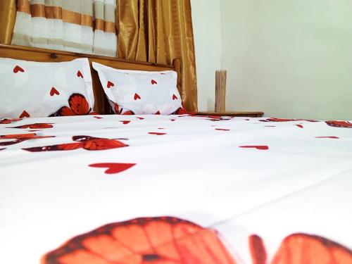 a white bed with red leaves on it at RÉSIDENCE NGUARY in Dakar
