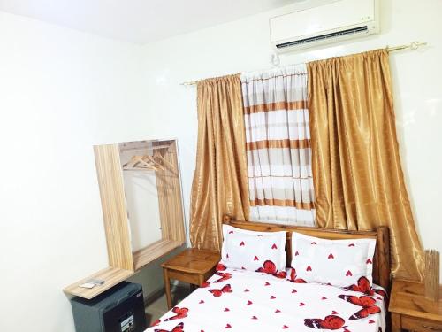 a bedroom with a bed with red flowers on it at RÉSIDENCE NGUARY in Dakar