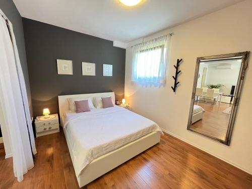 1 dormitorio con 1 cama grande y espejo en Studio Marina Zadar, en Zadar