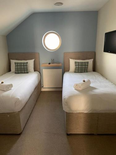 a room with two beds and a round window at Roseberry House in Newcastle Emlyn