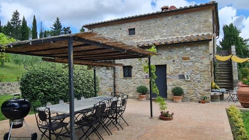 a patio with a table and chairs in front of a building at Podere Colombaio - Verbena in Radicofani