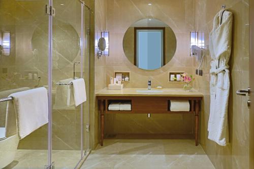 a bathroom with a shower and a sink and a mirror at Gift City Club, a member of Radisson Individuals in Gandhinagar