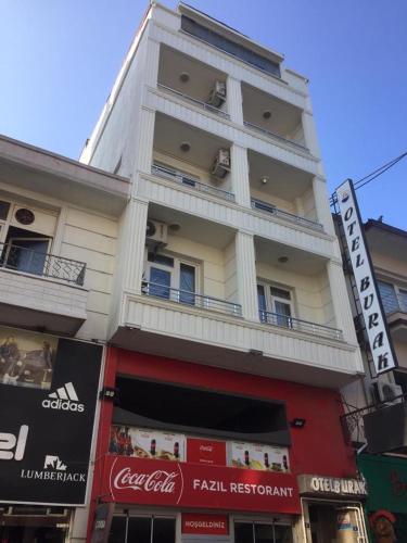a tall white building with balconies on a street at OTEL BURAK in Unye