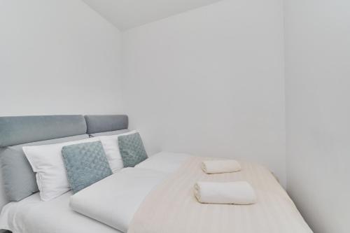 a white bed with two towels on top of it at Na Grobli Riverside Apartment & FREE GARAGE by Renters in Wrocław