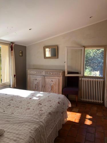 1 dormitorio con cama, espejo y ventana en Chambre au Cœur du Luberon, en Peypin-dʼAigues