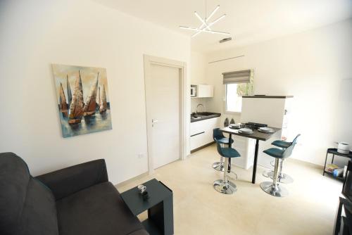a living room with a couch and a table and chairs at Zeituna Lodge a Porto Cesareo in Torre Lapillo
