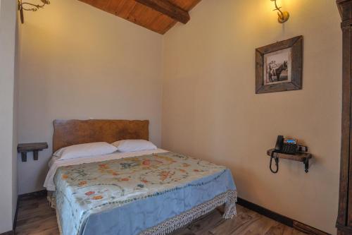 - une chambre avec un lit et un téléphone sur le mur dans l'établissement Sorella - Agriturismo-La Fattoria di San Francesco, à Pietraperzia