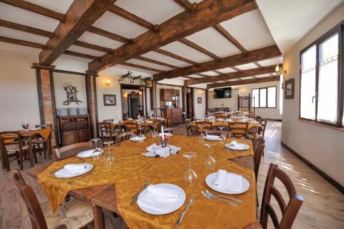 une grande salle à manger avec une grande table en bois dans l'établissement Sorella - Agriturismo-La Fattoria di San Francesco, à Pietraperzia