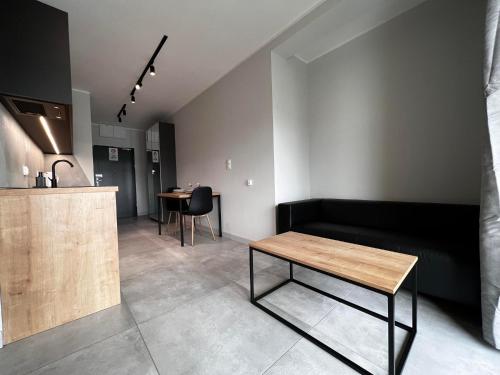 a living room with a black couch and a table at Property Apart – Legnicka Business Center in Wrocław