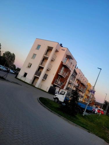 a white truck parked in front of a building at Apartament Słowińców 35 in Wejherowo