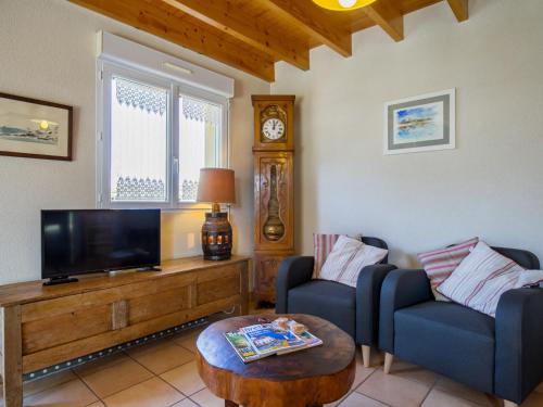 een woonkamer met 2 stoelen en een flatscreen-tv bij Holiday Home Rève de Plage by Interhome in Santec