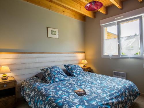 - une chambre avec un lit avec une couette bleue et 2 fenêtres dans l'établissement Holiday Home Rève de Plage by Interhome, à Santec