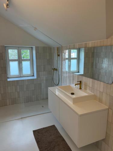 een witte badkamer met een wastafel en een spiegel bij APARTAMENT CENTRUM MIASTA PARKING in Nowy Sącz