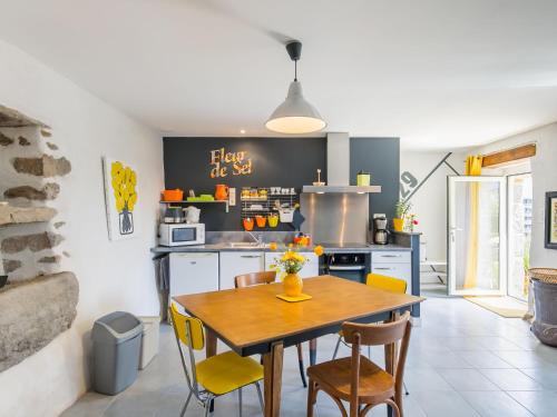 une cuisine avec une table en bois et des chaises jaunes dans l'établissement Holiday Home Aven by Interhome, à Trégunc