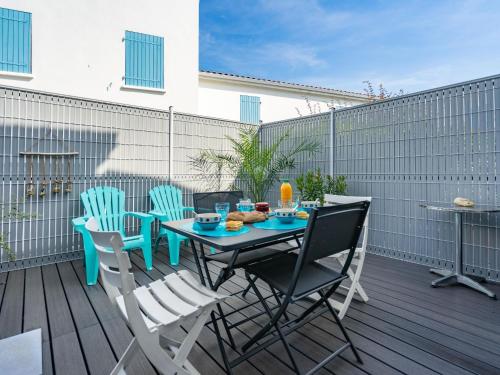 un patio avec une table et des chaises sur une terrasse dans l'établissement Holiday Home Les Jardins d'Agathe by Interhome, à Vaux-sur-Mer