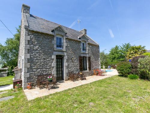 una antigua casa de piedra con bancos y un patio en Holiday Home Ty Keriquel by Interhome, en Névez