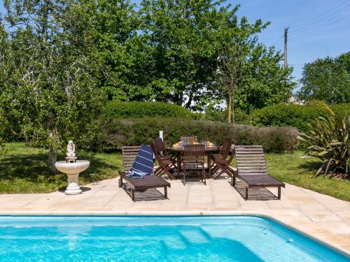 un patio avec une table et des chaises à côté d'une piscine dans l'établissement Holiday Home Ty Keriquel by Interhome, à Névez