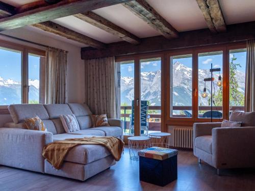 een woonkamer met een bank, stoelen en bergen bij Apartment Quille du Diable 44 by Interhome in Nendaz