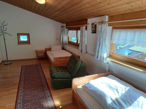 een slaapkamer met een bed, een bank en een raam bij Holiday Home Ragusa - ZAZ390 by Interhome in Hainzenberg