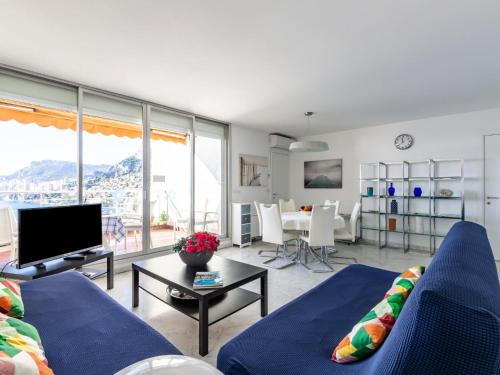 Apartment Parc Massolin - ROQ110 by Interhome في روكيوبرون كاب مارتن: غرفة معيشة مع أريكة زرقاء وتلفزيون