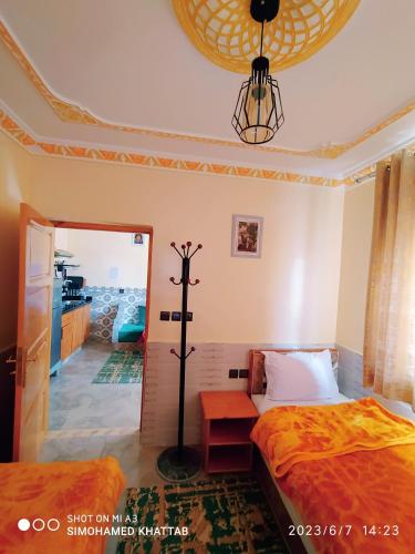 a bedroom with two beds and a cross on the wall at Chalets ITO Atlas Timnay in Midelt