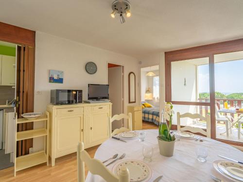 une cuisine et une salle à manger avec une table et des chaises dans l'établissement Apartment Les Balcons de l'Atlantique-10 by Interhome, à Pontaillac