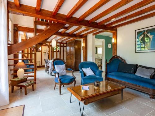 un salon avec un canapé bleu et des chaises dans l'établissement Holiday Home Petit Champ by Interhome, à Trouville-sur-Mer
