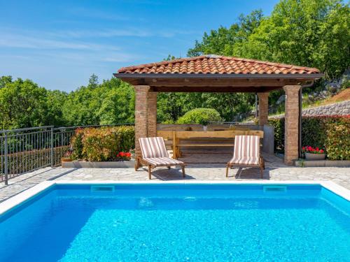 a swimming pool with two chairs and a gazebo at Holiday Home Villa Toni - OPA301 by Interhome in Kastav