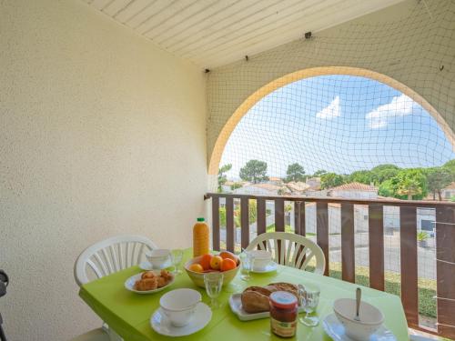 a green table with food on top of a balcony at Apartment Les Balcons de l'Atlantique-11 by Interhome in Pontaillac