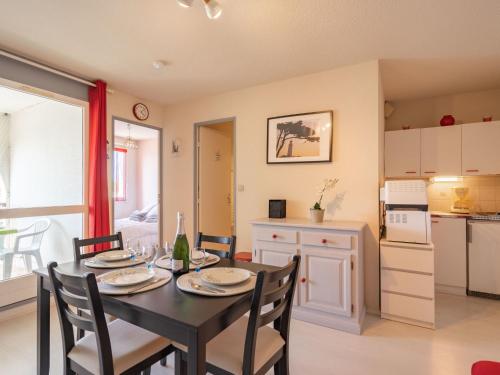 uma cozinha e sala de jantar com mesa e cadeiras em Apartment Les Balcons de l'Atlantique-11 by Interhome em Pontaillac