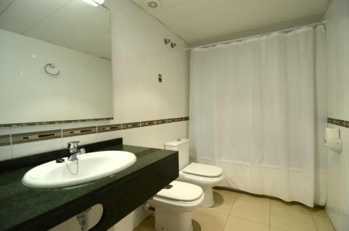 a bathroom with a sink and a toilet and a mirror at Apartamentos Mestral in L'Escala