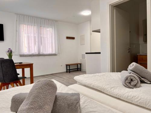 a room with a bed and a table and a kitchen at GrenzApartments in Bietingen