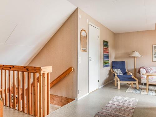 a room with a staircase and a blue chair at Holiday Home Mölltorp by Interhome in Mölltorp
