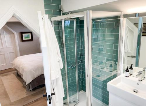 bagno con doccia, lavandino e letto di Cluain Ard Holiday Home 