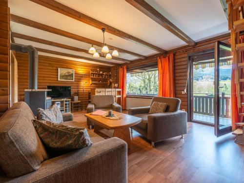 ein Wohnzimmer mit einem Sofa, Stühlen und einem Tisch in der Unterkunft Apartment Am Hohen Bogen-45 by Interhome in Arrach