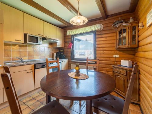 Una cocina con mesa y sillas en una cabaña. en Apartment Am Hohen Bogen-45 by Interhome, en Arrach